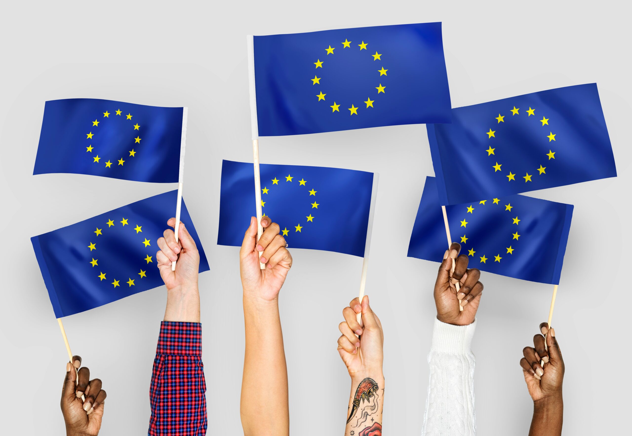 Diverse hands raising European Union flags