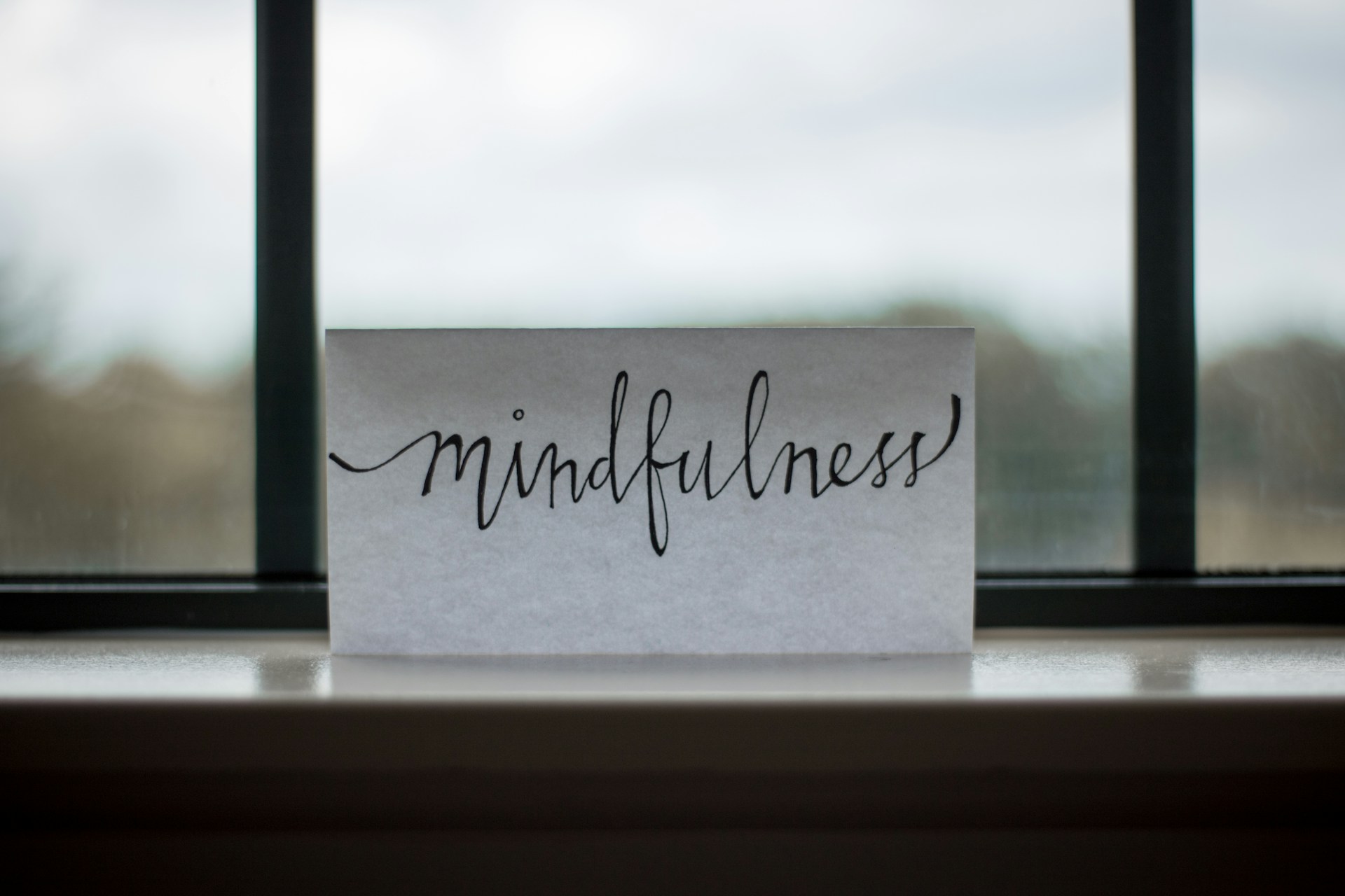 Handwritten card reading mindfulness on a windowsill
