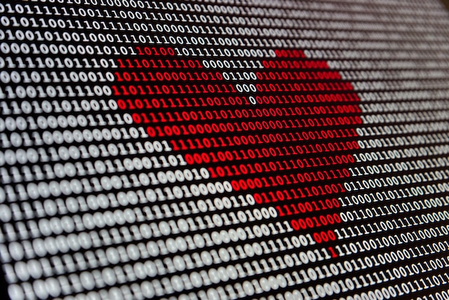 Red heart shape made of binary code on a screen