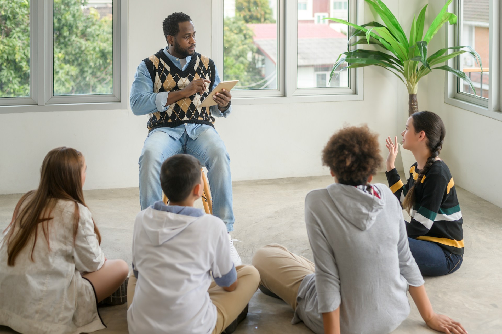Teacher reading from a book to students seated on the floor